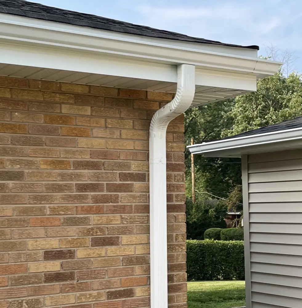 Gutters and downspout installed along a brick home